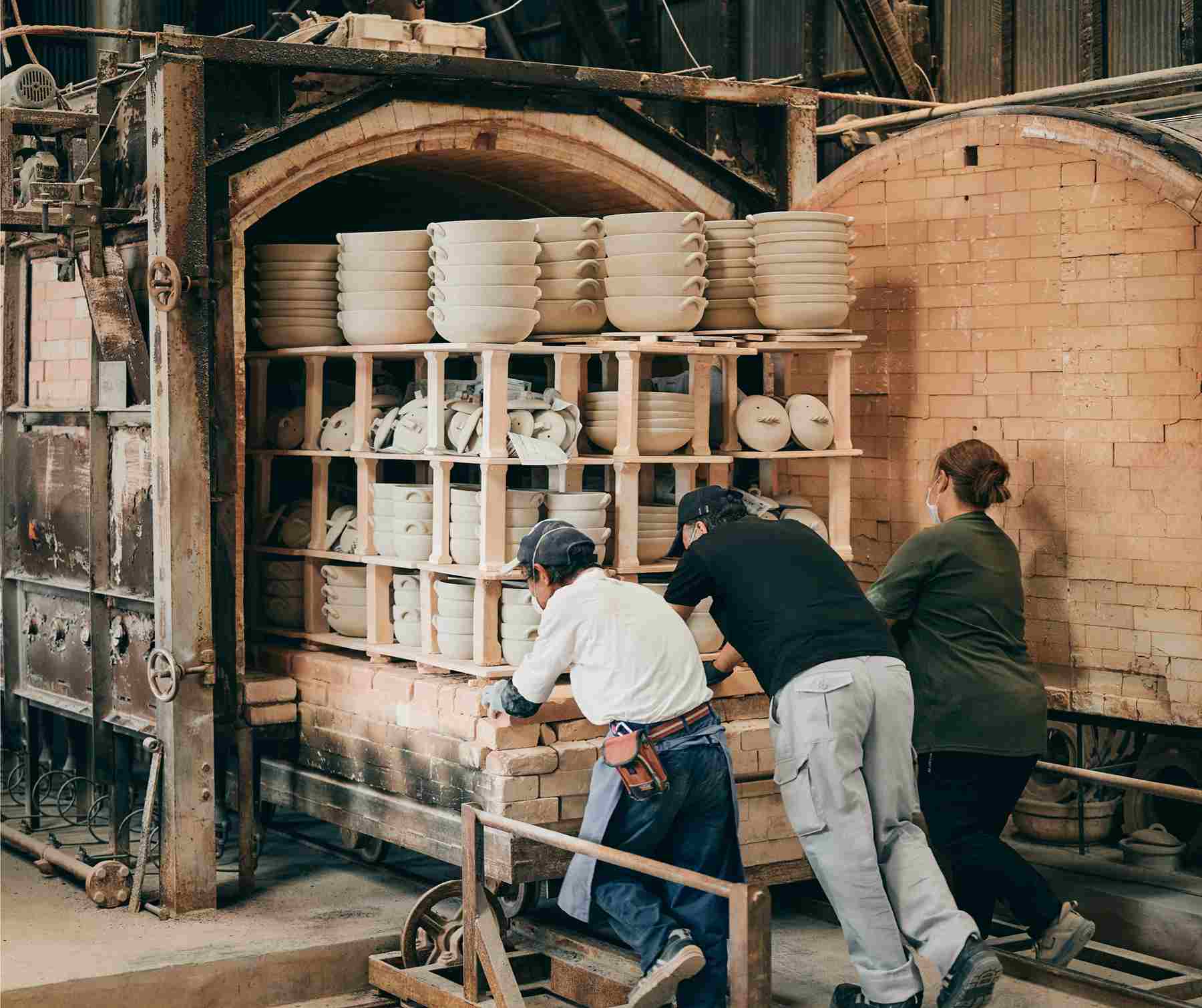 大きな窯へ陶器を入れる様子